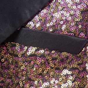 Gedetailleerde close-up van paarse en gouden pailletten op een heren colbert voor podium