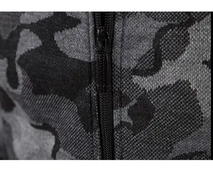 Close-up detail of the smooth black zipper on a grey camouflage knit sweater jacket.