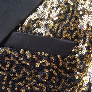 Detailopname van glanzende goud-zwarte lovertjes op een heren colbert voor podium.