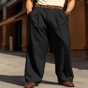 Vista inferiore dei pantaloni neri larghi da uomo abbinati a cintura e scarpe marroni.