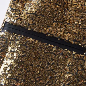 Gedetailleerde macro-opname van gouden pailletten op een herencolbert voor optredens