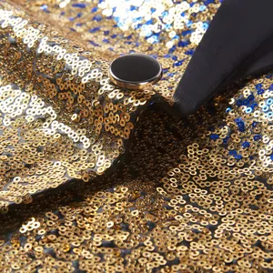 Detailopname van sprankelende goud- en blauwe pailletten op een herenpodiumblazer.
