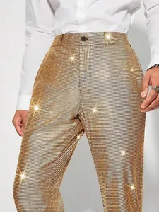Gros plan détaillé montrant la texture de grille à paillettes dorées du pantalon de soirée