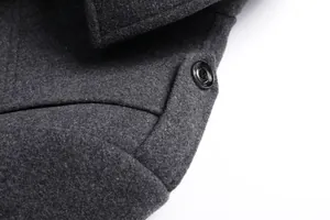 Makroansicht der dunkelgrauen Wollstofftextur und des schwarzen Knopfes am Herrenmantel