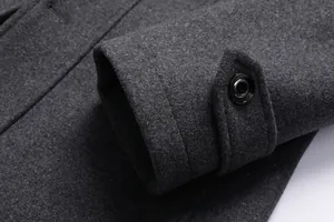 Nahaufnahme eines dunkelgrauen Wollmantel-Ärmels mit einem glänzenden Knopf-Detail.