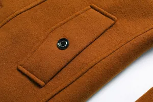 Detailansicht der Tasche und des Knopfes eines braunen Wollmantels für Herren im Winter