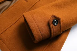 Detailansicht eines herren wollmantels in orange mit dekorativem knopf am ärmel