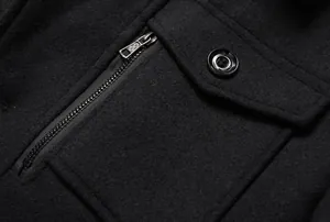Makro-Detail eines hochwertigen schwarzen Wollmantels für Herren mit Taschen- und Reißverschluss