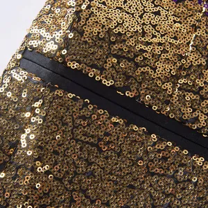 Detailopname van een glinsterende herenblazer met gouden lovertjes voor podiumoptredens.