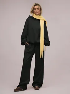 Trendiges Damen-Set aus schwarzem Oversize-Hoodie und weiter Hose mit gelbem Schal
