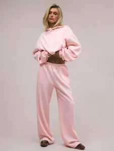 Model trägt einen gemütlichen rosa Kapuzenpullover mit passender weiter Hose.
