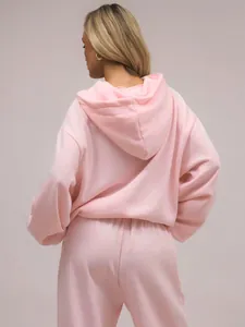 Detailansicht der Rückseite eines weichen, rosa Oversized-Kapuzenpullover-Sets für Damen.