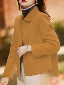 Dettaglio cappotto corto in lana cammello da donna con colletto a rever e bottoni.