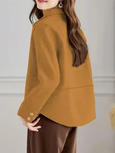Dettaglio profilo laterale di un cappotto corto in lana giallo senape per l'autunno