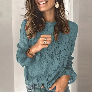 Nahaufnahme einer türkisfarbenen Spitzenbluse mit filigranen, hohlen Blumenmustern