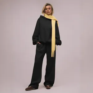Schicker schwarzer Oversized-Kapuzenpullover und weite Jogginghose im Set für Damen.