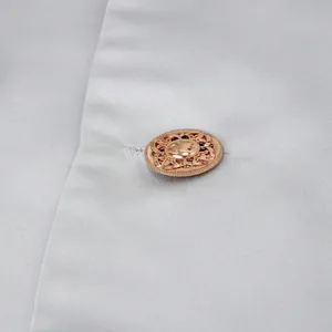 Macro detail of a rose gold filigree button on a light silver men's business suit