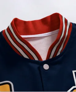 Detailed view of the ribbed knit stand collar and snap button of a navy varsity jacket