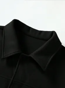 Detailed view of black woolen jacket lapel collar with high-quality fabric texture
