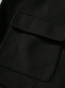 Close-up macro view of a flap pocket on a black woolen jacket showing soft fabric texture