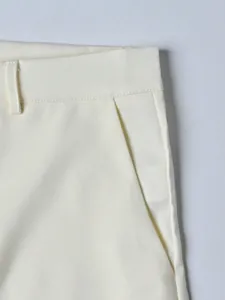 Close-up of off-white men's suit trousers showing pocket detail and twill fabric texture