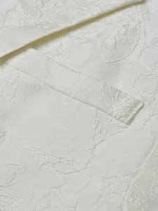 Close-up detail showing the premium white jacquard fabric with subtle floral patterns