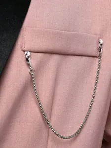Macro view of a silver decorative chain attached to a stylish pink men's blazer pocket