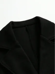 Close-up detail of a classic black woolen coat collar showing high-quality fabric texture.