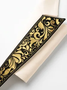 Macro view of gold foil baroque floral print on white men's banquet suit blazer lapel