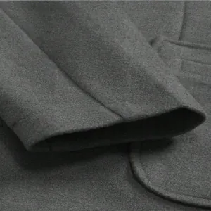 Close-up detail of grey wool coat sleeve cuff and soft felt fabric texture