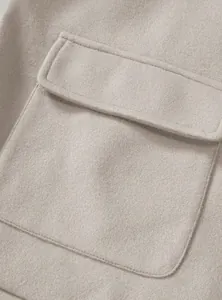 Close-up detail of the pocket and soft woolen texture on a beige men's jacket