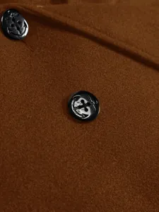 Detailed view of the black anchor pattern buttons on a brown wool overcoat for men