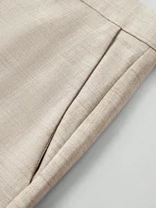 Close-up of premium textured beige fabric and pocket detail on men's business suit jacket