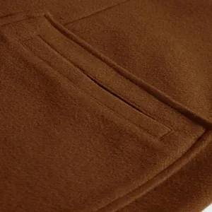 Close-up detail showing the premium brown wool fabric texture and stitching on men's overcoat