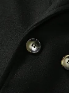 Gros plan de boutons en corne sur un manteau en laine noire de qualité pour hommes.