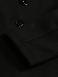 Detailed view of the premium black wool fabric and buttons on this men's coat.