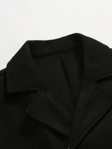 Close-up detail of a classic black wool coat collar showing fabric texture and stitching
