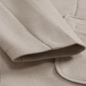 Close-up of beige men's woolen coat showing sleeve cuff and soft fabric texture