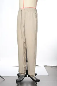 Side view detail of men's loose casual straight leg drawstring pants in light beige