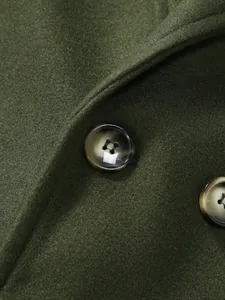 Détail macro du manteau en laine vert olive avec boutons marbrés et texture de tissu fine