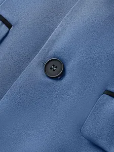 Detailed macro shot of premium blue business suit fabric texture with black button detail.