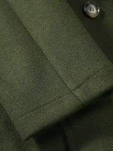 Gros plan sur le détail de la manche d'un manteau en laine vert olive montrant la texture