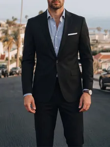 Detail of a professional black men's business suit set with a striped shirt.