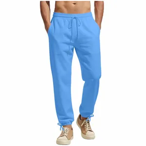 Full view of men's loose blue drawstring casual trousers showing fit and fabric texture