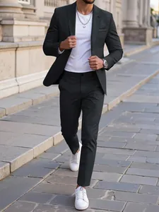 Men's sleek black slim-fit casual suit set styled with white sneakers for a modern commuter look