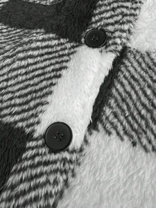 Close-up detail of soft plaid plush fabric and black buttons on a men's jacket