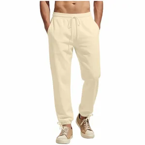 Detail view of men's cream-colored loose-fit sweatpants with drawstring and elasticated cuffs