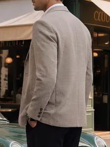 Detailopname van grijze herenblazer met textuur en knoopdetails op de mouwen voor zaken