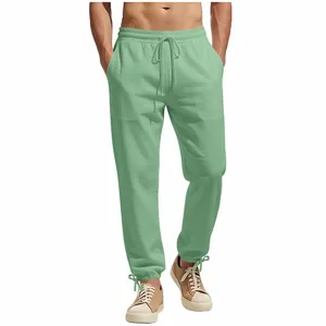 Detail view of mint green men's casual drawstring trousers with unique ankle tie design