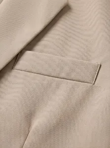 Nahaufnahme der Tasche und der hochwertigen Stofftextur eines khakifarbenen Business-Blazers